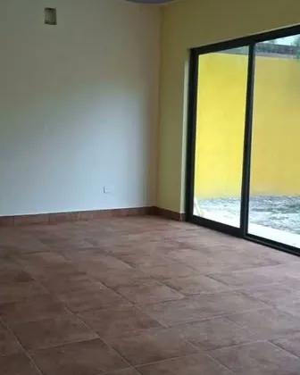 Estancia con piso de barro y cancel hacia el patio