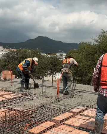 Equipo de obra armando una losa con la sierra al fondo