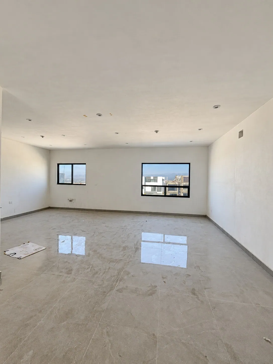 Sala comedor con piso claro y ventanas al exterior